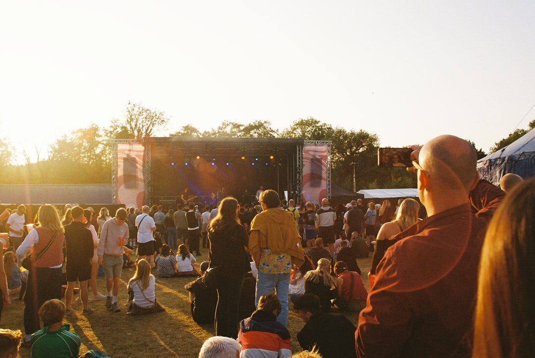 Large crowd enjoying an outdoor music festival at dusk